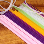 Colorful plastic straws and tubes on a wooden surface