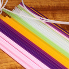 Colorful plastic straws and tubes on a wooden surface