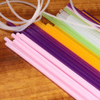 Colorful plastic straws and tubes on a wooden surface