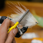An ergonomic yellow powder-coated comb with a stainless steel shaft and teeth, designed for fly tying in fishing.