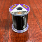 Spool of black Wapsi Ultra Wire UTC with a purple label on a wooden surface