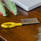 Yellow-handled Loon comb on a wooden surface with fly fishing flies in the background