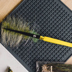 Fly fishing fly on a black mat with a yellow Loon Ergo D-Loop Tweezer