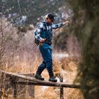 Man fishing from a wooden platform in a natural setting with mountains in the background wearing Simms MEN's Freestone Wading Boot - Rubber Soles