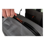 Person opening a gray backpack with a close-up of the zipper mechanism.