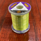Spool of green Wapsi Ultra Wire UTC with a purple label on a wooden surface