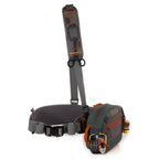 A Fishpond Switchback Belt System 2.0 with various pockets and straps, featuring a wader belt and a shoulder strap, in green, gray, and orange colors.