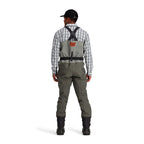 Person wearing Simms Men's Freestone Stockingfoot Waders, featuring gray upper and lower layers with black suspenders and red adjustment straps.