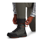 Person wearing Simms Men's Freestone Stockingfoot Waders, featuring gray upper and lower layers with black suspenders and red adjustment straps.