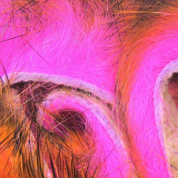 Close-up of a pink and orange Hareline Tiger Barred 1/8” Rabbit Strips