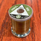 Spool of Wapsi UTC Vinyl Rib on a wooden surface