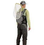 Man wearing waders and a Gray Simms Dry Creek Z Sling Pack with a fishing net on a white background