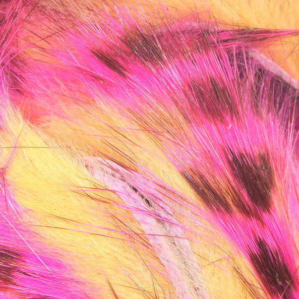 Close-up of  pink, yellow, and black Hareline Tiger Barred 1/8” Rabbit Strips