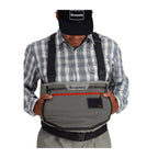 Person wearing Simms Men's Freestone Stockingfoot Waders, featuring gray upper and lower layers with black suspenders and red adjustment straps.