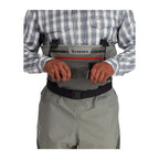 Person wearing Simms Men's Freestone Stockingfoot Waders, featuring gray upper and lower layers with black suspenders and red adjustment straps.
