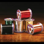 Spools of wire in various colors on a wooden surface