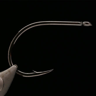 Kona Big Game Hunter (BGH) Fishing hook held in a fly tying vise against a black background