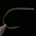 Kona Big Game Hunter (BGH) Fishing hook held in a fly tying vise against a black background