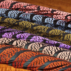 Colorful Hareline Lady Amherst Center Tail Feather on a wooden surface