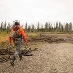 Fishing angler wearing a Fishpond Summit Sling Pack 2.0 while wading a river.