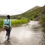 Angler wearing a Fishpond Thunderhead Submersible Lumbar Pack in yucca color
