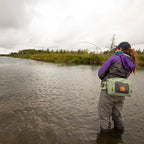 Angler wearing a Fishpond Thunderhead Submersible Lumbar Pack in yucca color