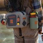 Angler wearing a Fishpond Thunderhead Submersible Lumbar Pack in gray color