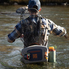 Angler wearing a Fishpond Thunderhead Submersible Lumbar Pack in gray color