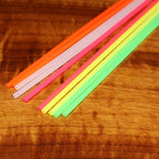 Colorful plastic straws and tubes on a wooden surface