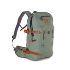 A green Fishpond Thunderhead Submersible Backpack with orange trim and various compartments, equipped with a sturdy harness system.
