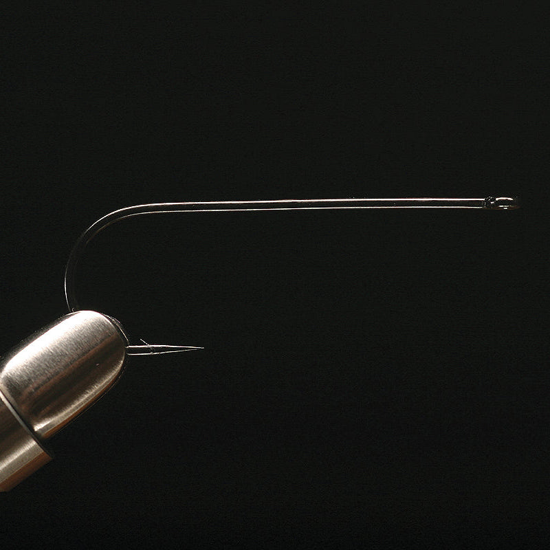 A single gold-colored Daiichi 2461 streamer fishing hook against a black background.