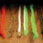 Set of colorful Hareline 1/4" Magnum Rabbit Strips on a textured brown background