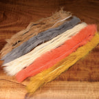 Colorful Hareline Rabbit Strips 1/8" on a wooden surface